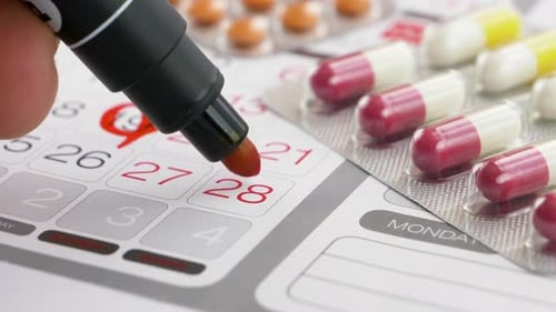 Marking Medication Schedule on Calendar with Pills