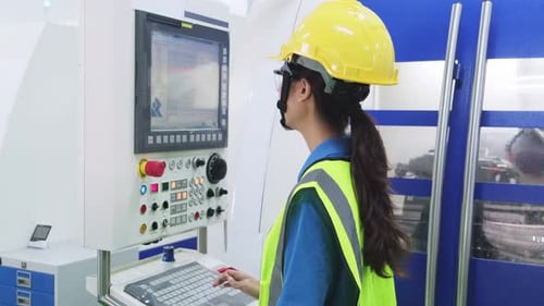 Trabalhadora asiática usando capacete de proteção e óculos na linha de produção da fábrica.