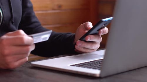 Person Using Phone and Holding Credit Card
