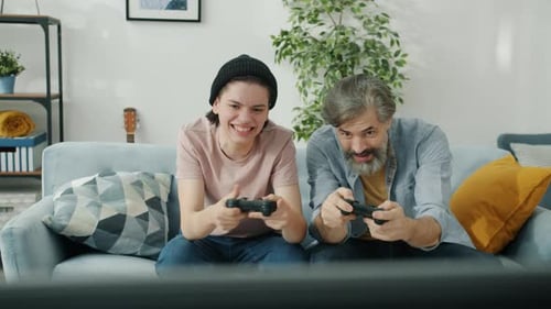 Father and Son Playing Video Games Together at Home