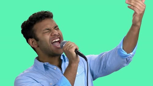 Young Man Singing Into Microphone on Chroma Key