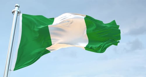 Waving Nigerian Flag on Pole Against Cloudy Sky