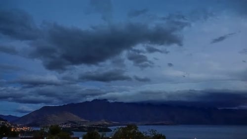 Dark Night Over Mountains and Cityscape