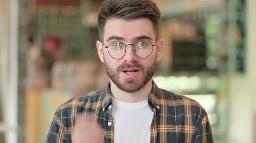 Man Smiles and Points a Finger at Camera