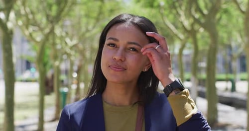 Portrait of african american woman looking at camera and smiling in street