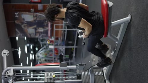 Determined Man Doing Cable Row Exercise at Gym