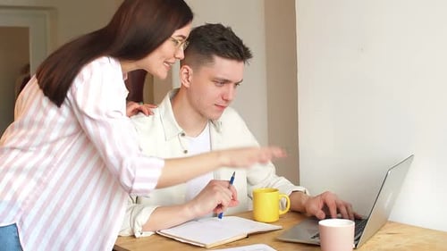 Young Couple Working Together at Desk Indoors