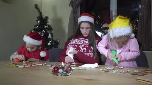 Girls Decorating Christmas Gingerbread Cookies at Home