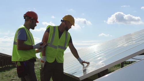 Solar Panel Technicians Examining Renewable Energy Installation