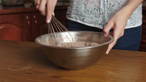 Frau verquirlt Zucker, Mehl und Kakaopulver
