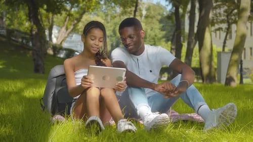 Young Friends Viewing Tablet in City Park