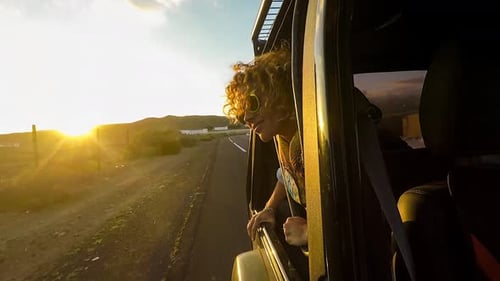 Woman Leans Out of Car Window at Sunset