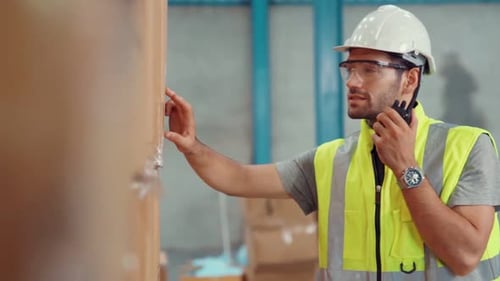 Trabajador de carga profesional habla por radio portátil para contactar a otro trabajador