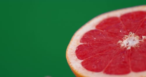 Bright Grapefruit with Water Droplets on Green Screen