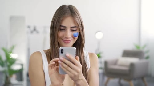 Young Woman Using Smartphone in Bright Home