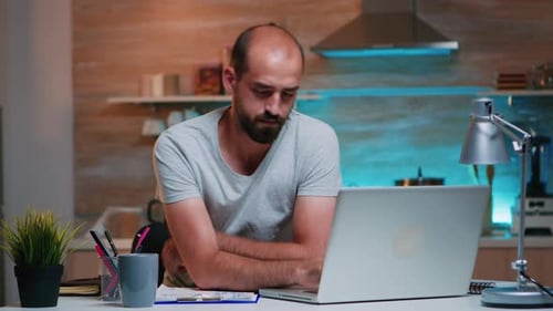 Man Working on Laptop With Headache
