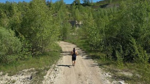 Unrecognizable Sportsman Running on Countryside Road, Drone View Tracking Shot of Anonymous Male
