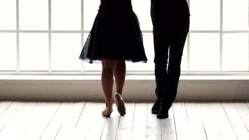 Elegant Couple Dancing Gracefully in Front of a Window
