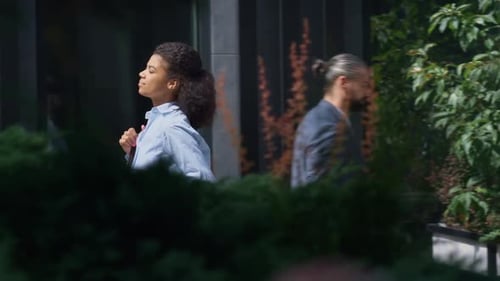Smiling Businesswoman Holding Coffee Cup Walking Business District on Sunny Day