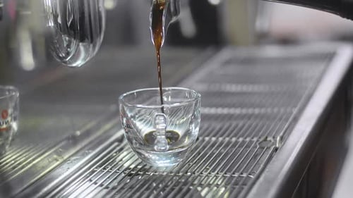 Espresso Pouring Into Glass Cup From Machine