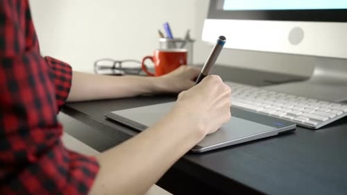 Young Adult Using Graphic Tablet at Desk