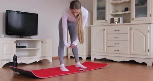 Blonde Woman Stretching on a Mat Indoors