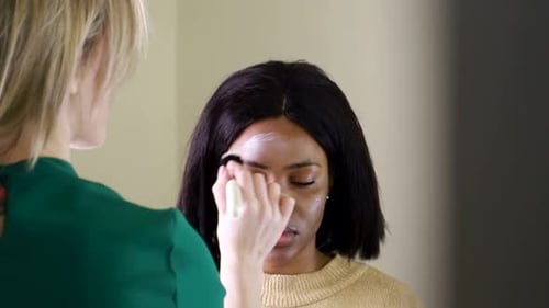 Makeup Artist Applies Makeup To Model's Forehead