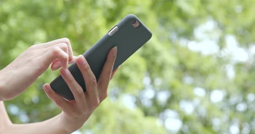 Frau benutzt Handy auf grünem Hintergrund