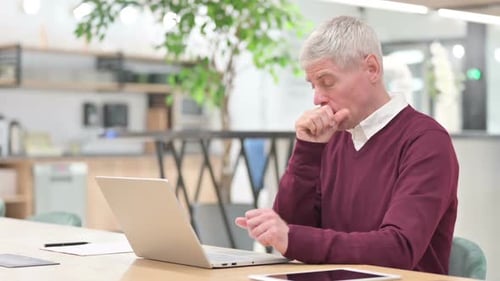 Man Coughing While Working At His Laptop