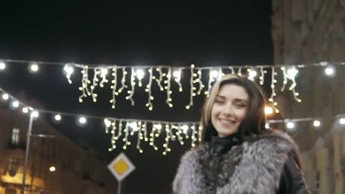 Young Beautiful Pretty Woman Smiling at City Street in the Night Against Evening Lights