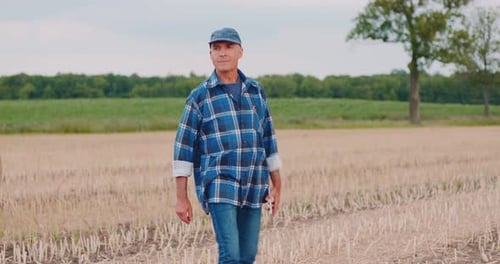 Farmer Using Digital Tablet While Examining Field