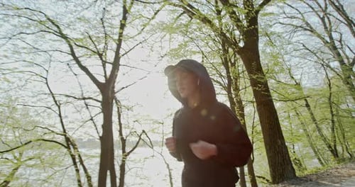 Woman in Hoodie Jogging in Park
