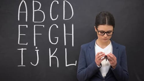 Frustrated Teacher Showing Empty Wallet, Poor Funding, Alphabet on Blackboard