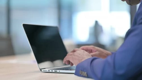 Rear View of Young Businessman Using Laptop