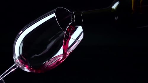 Red Wine Poured into Glass in Dark Setting