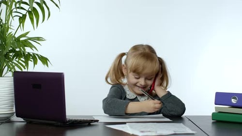 Young Girl Answers Phone While Doing Homework