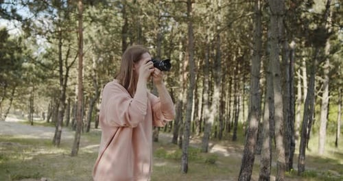 Young Woman Photographer Takes Pictures of the Forest Using Digital Camera