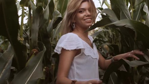 Young Woman Walking Through Rural Cornfield