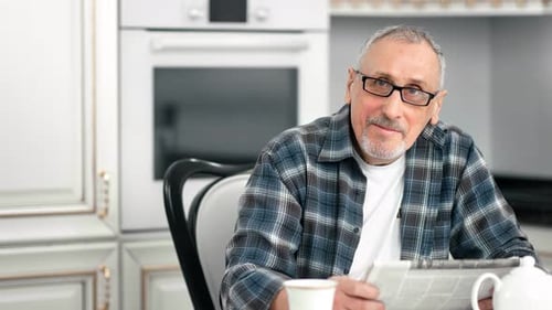 Portrait of Casual Elderly Bearded Man Posing at Kitchen Smiling Looking at Camera