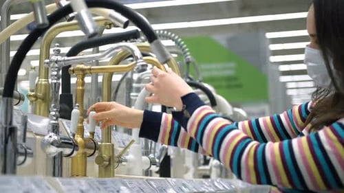 Woman Choosing a Water Tap in Plumbing Store