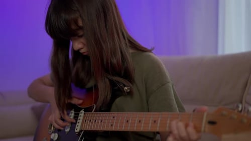 Girl Plays Electric Guitar in a Cozy Home