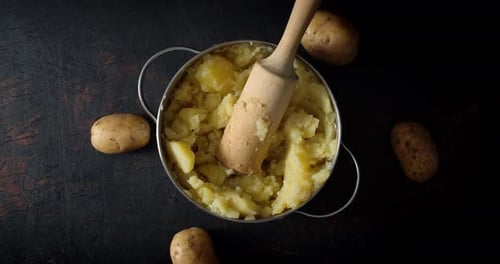 Mashed Potatoes in Pot with Wooden Masher