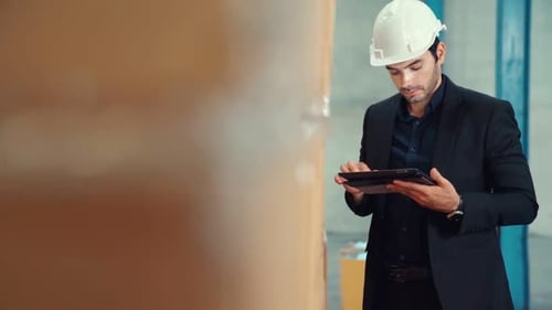 Factory Manager Using Tablet Computer in Warehouse or Factory