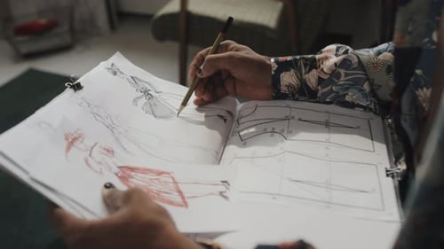 Artist Sketching Fashion Designs on Paper