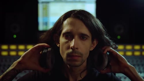 Young Man Listening Music in Recording Studio. Composer Turning To Soundboard.