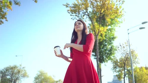 A Girl in Red Dress Walking Around the City and Drinking Coffee