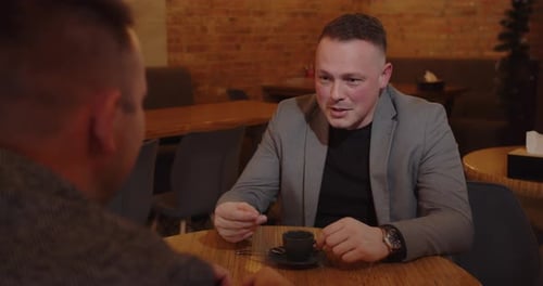 Two Business Partners In A Cafe Drinking Coffee And Having A Pleasant Conversation