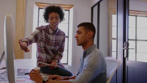 Colleagues Discussing Work at Computer in Office