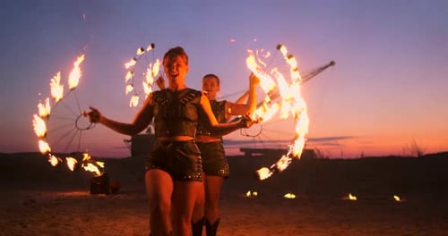 Professionelle Künstler zeigen eine Feuershow bei einem Sommerfestival im Sand in Zeitlupe
