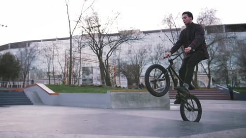 BMX Rider Doing Tricks in Street Plaza Bicycle Stunt Rider in Cocncrete Skatepark Super Slow Motion
